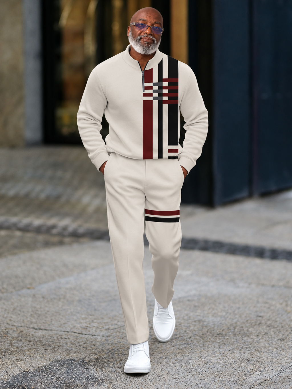 Model wearing cream half-zip track suit with burgundy and black geometric stripes