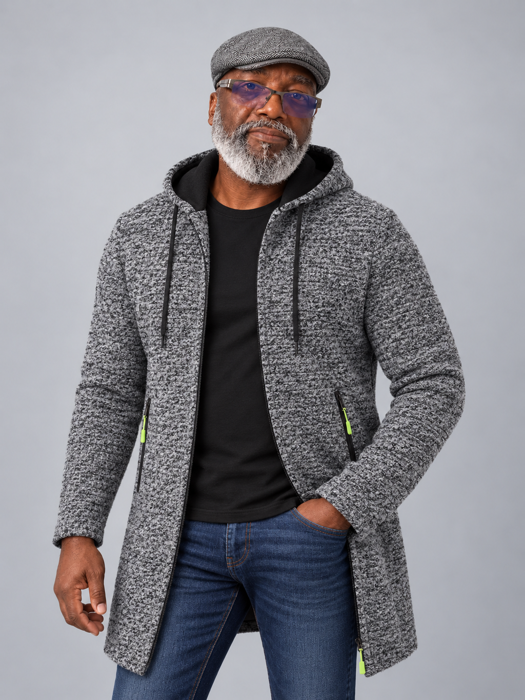 Model wearing the black gray hooded mid-length sweater jacket with a gray flat cap